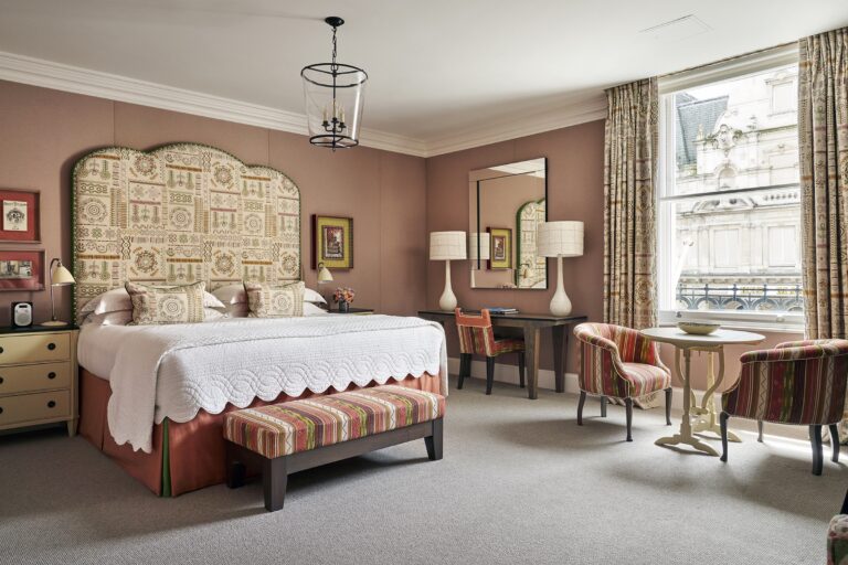 A Luxury Junior Suite, with a pink headboard, Haymarket Hotel