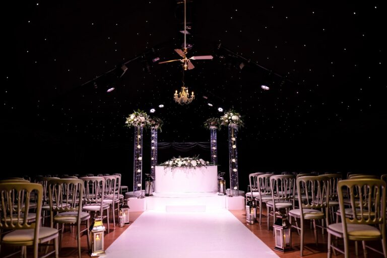 The Under the Stars ceremony room, with a starlit black ceiling, chandelier and a lit aisle, Heaton House Farm