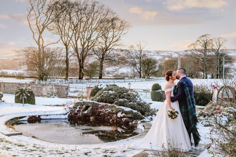 The water gardens under snow, with a couple by the frozen pond, Heaton House Farm
