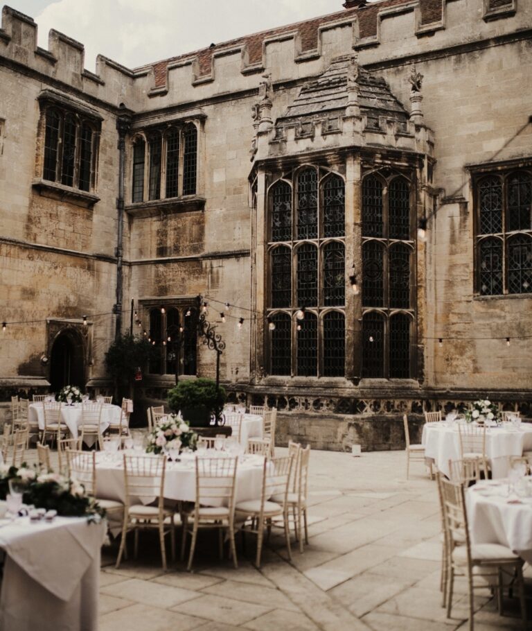 The Italian-style courtyard set with round tables for dining within the Tudor stone walls, Hengrave Hall