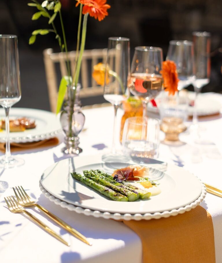 A plated first course of asparagus, with orange blooms and gold cutlery on the table, Hengrave Hall