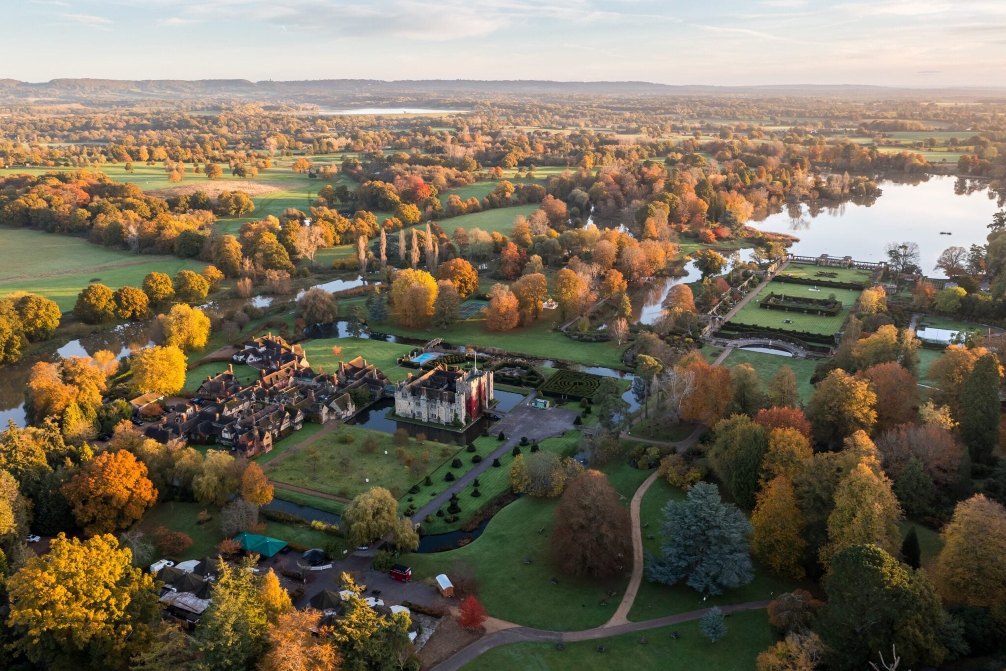 An aerial view of the castle, gardens and lake in the Kent countryside in autumn, Hever Castle