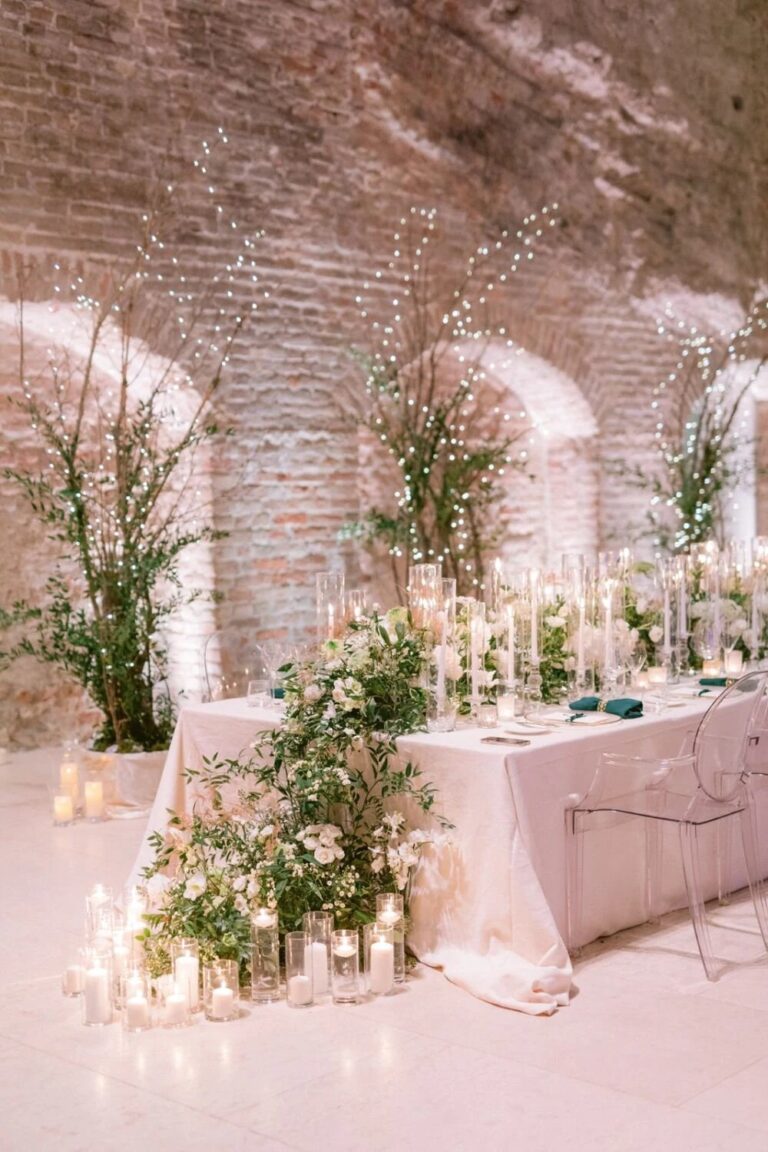 Sweetheart table among candles and greenery in a brick vault at Palais Coburg, Vienna, High Emotion Weddings
