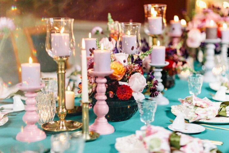Candles and bright florals on a teal-clothed table at Burg Schlitz, Germany, High Emotion Weddings
