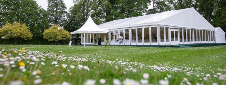 A framed marquee on the South Lawn across a meadow of wildflowers, Hillsborough Castle and Gardens