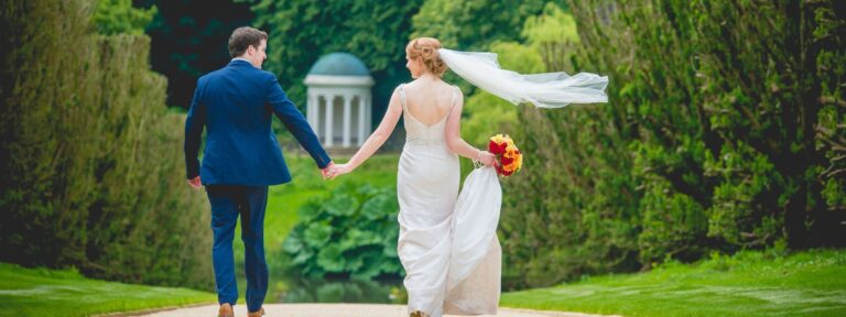 A bride and groom walking the gardens beside a garden temple, Hillsborough Castle and Gardens