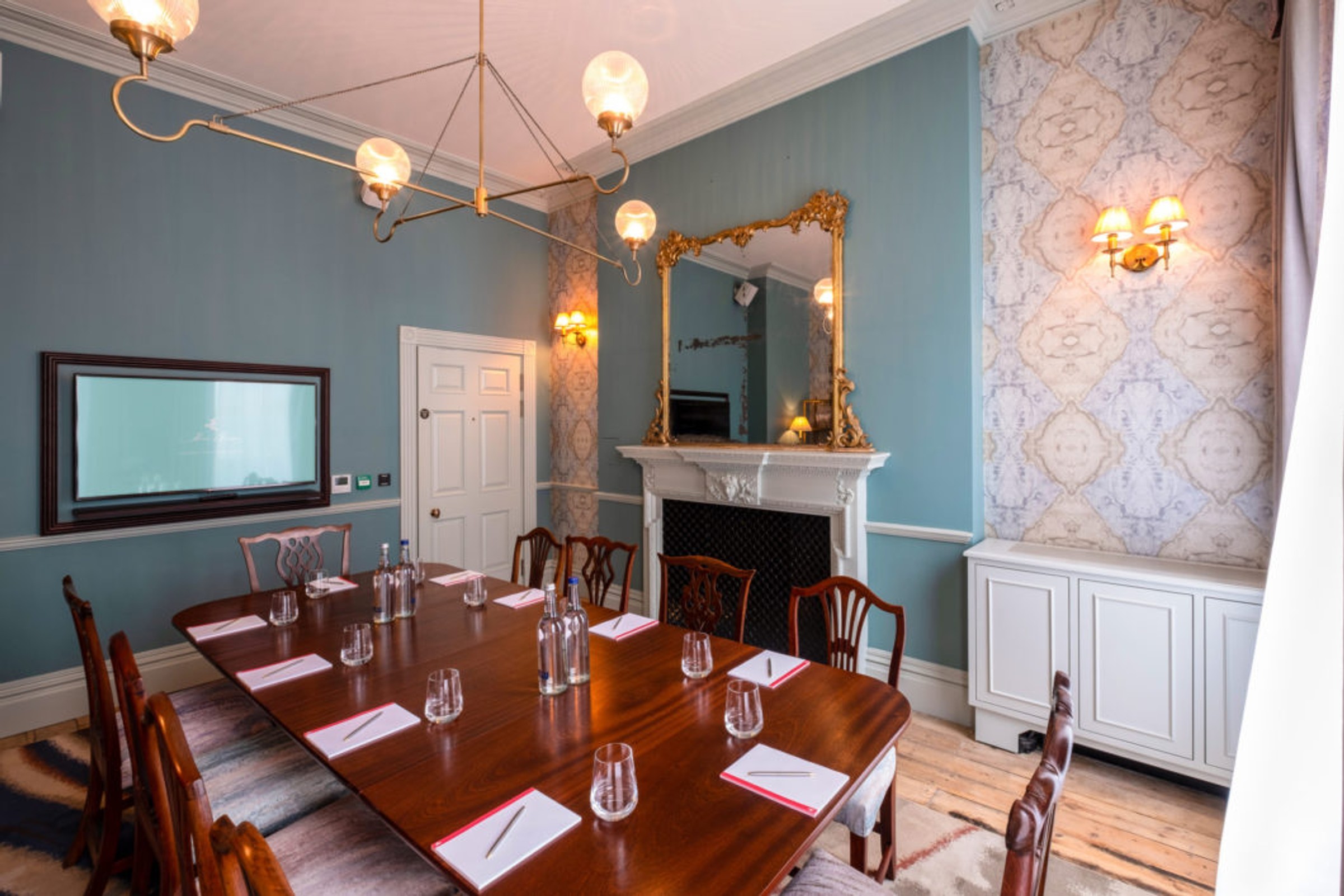 A long dining table in a blue-papered private room, Home House