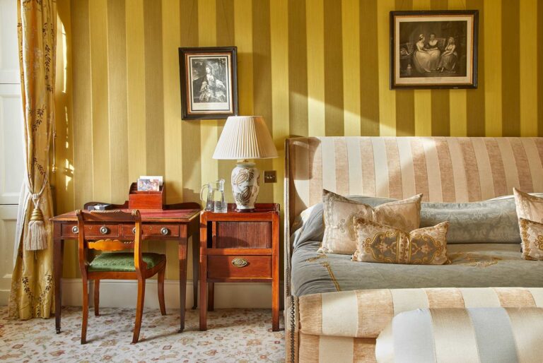 A bedroom with gold striped walls, Home House