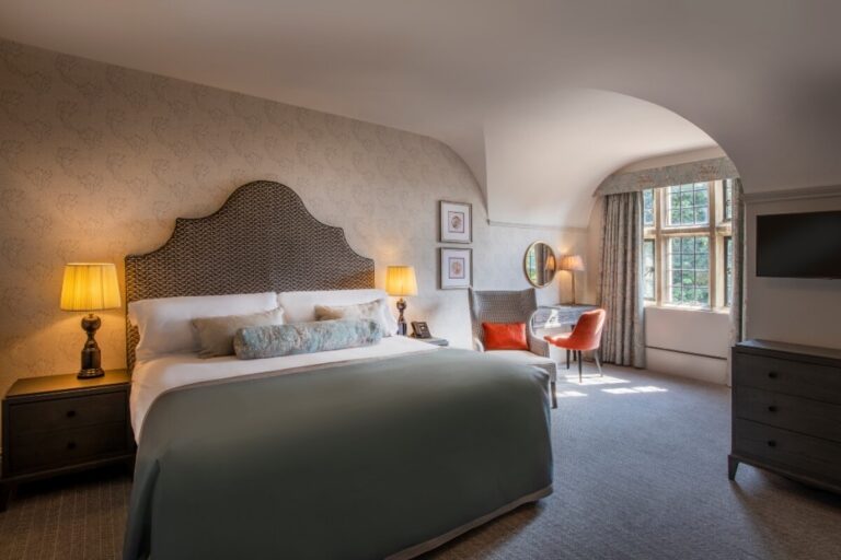 A Manor Suite bedroom with an upholstered headboard and a leaded window, Horwood House Hotel & Spa