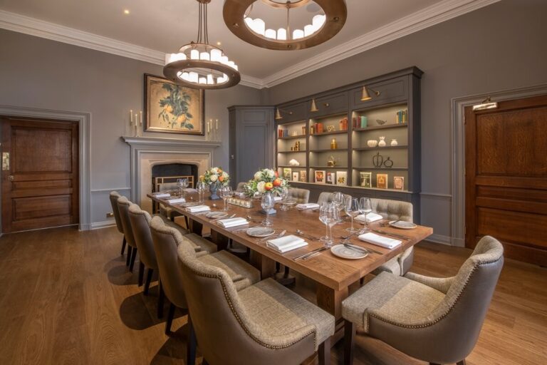 The Manor Library set for a private dinner, with a stone fireplace and bookshelves, Horwood House Hotel & Spa