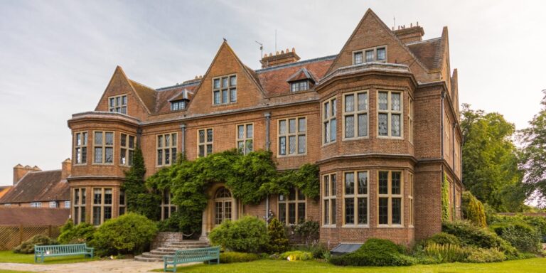 The Manor House from the garden side, its bay windows and gables above wisteria and the stone steps to the lawn, Horwood House Hotel & Spa