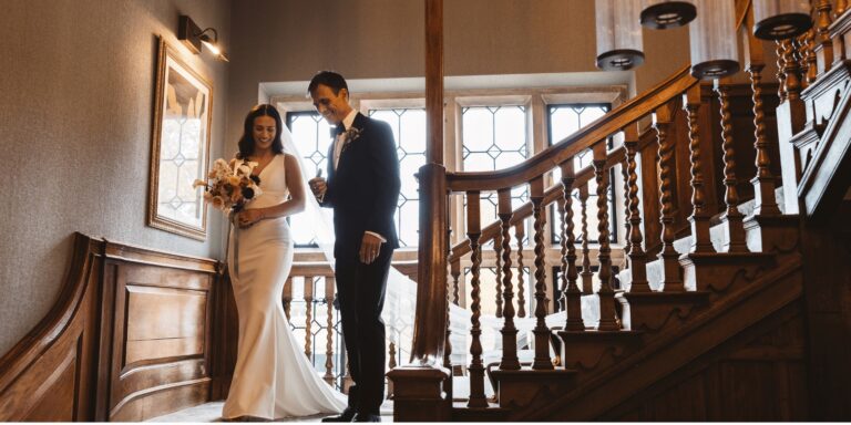 A couple beside the carved oak staircase and leaded windows in the Manor House, Horwood House Hotel & Spa