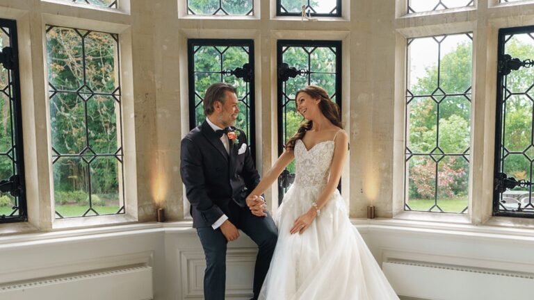 A couple in a stone-mullioned bay window with leaded glass, looking out to the gardens, Horwood House Hotel & Spa