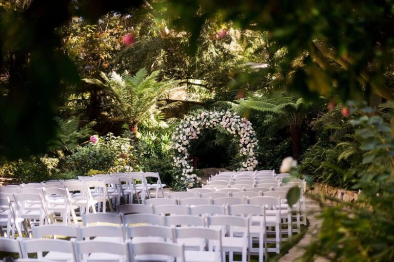A wedding ceremony at Swan Lake, beneath a floral arch, Hotel Bel-Air
