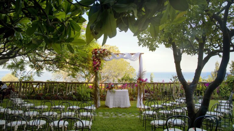 A symbolic ceremony set up on the garden lawn with an arch and chairs, Hotel Santa Caterina