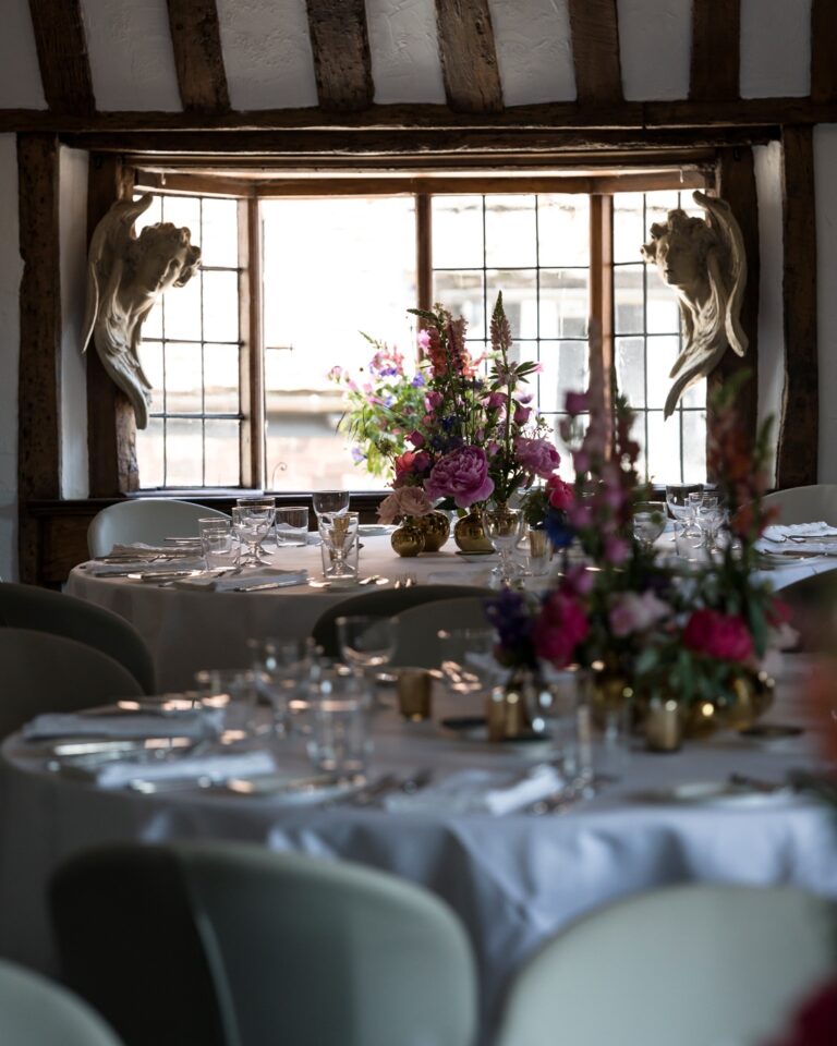 A wedding table dressed with garden flowers by a timbered window, Hotel Tresanton