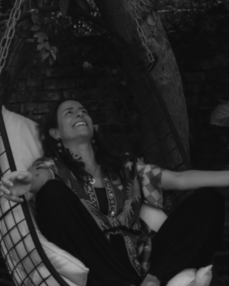 A guest laughing in a hammock by the sea, Hotel Tresanton