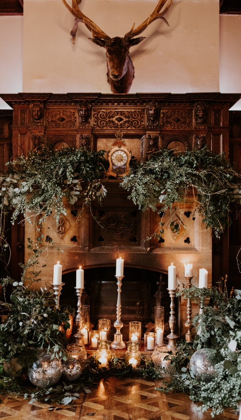 The Great Hall fireplace dressed with greenery and candles, Huntsham Court