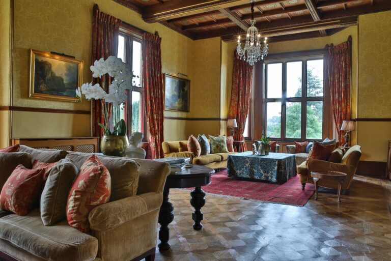 A drawing room with sofas and a view over the gardens, Huntsham Court