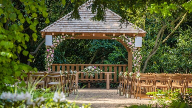 The Outdoor Ceremony Garden, an oak structure and wooden seating under the woodland canopy, Hylands Estate