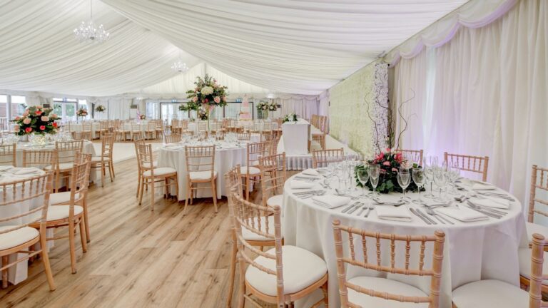 The Grand Pavilion under ivory drapes, tables set for the wedding breakfast, Hylands Estate