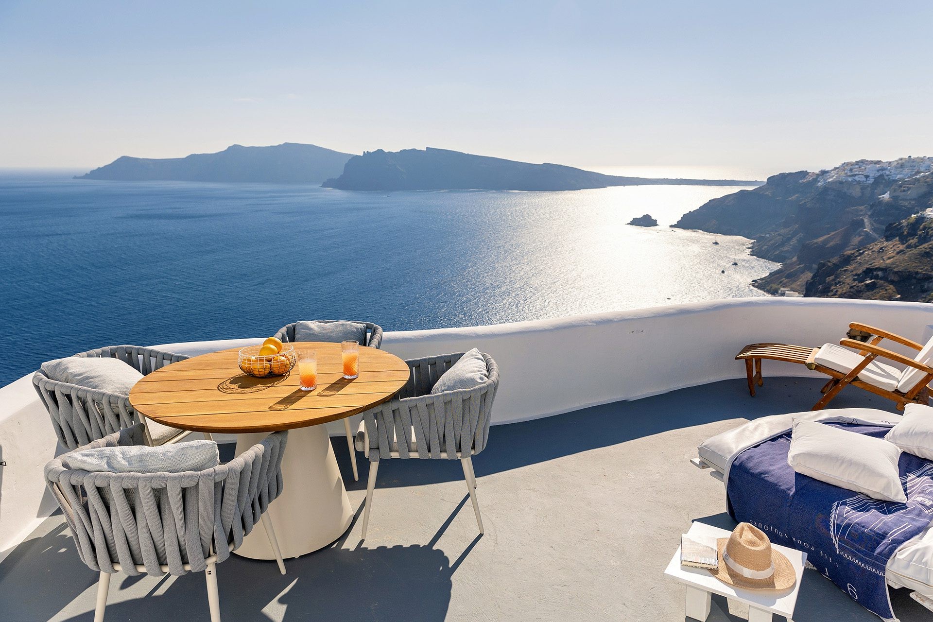 A terrace dining table above the caldera and the cliffs of Oia, Ikies Traditional Houses
