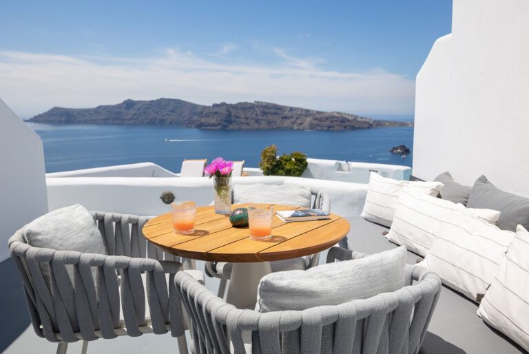 A terrace table and lounge seating with the volcano beyond, Ikies Traditional Houses