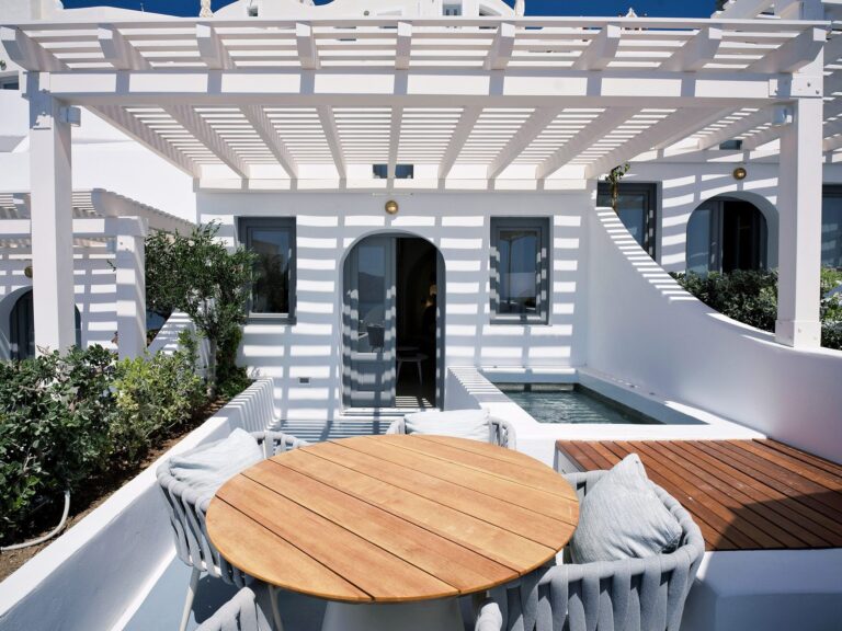 A terrace with a hot tub and a round dining table, Ikies Traditional Houses