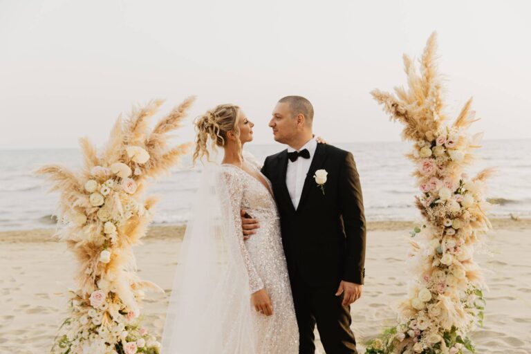 The couple on the sand between two columns of pampas grass and blush roses, Versilia coast, Il Giorno Perfetto di Glenda Marradi