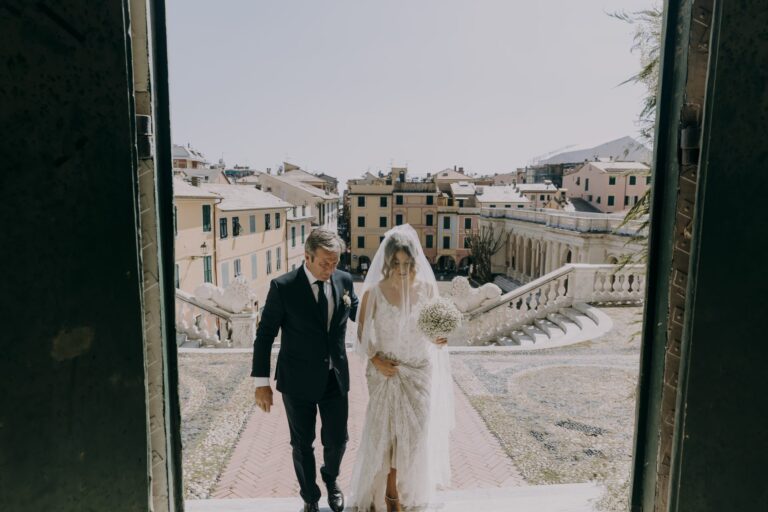 The bride and her father walking down the steps of a coastal village of painted houses, Il Giorno Perfetto di Glenda Marradi