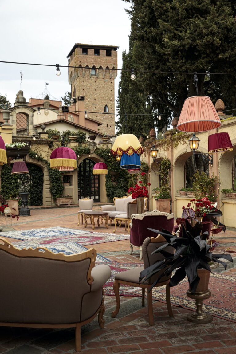 A Tuscan villa courtyard dressed with coloured fringed lampshades, antique sofas and rugs, Il Giorno Perfetto di Glenda Marradi