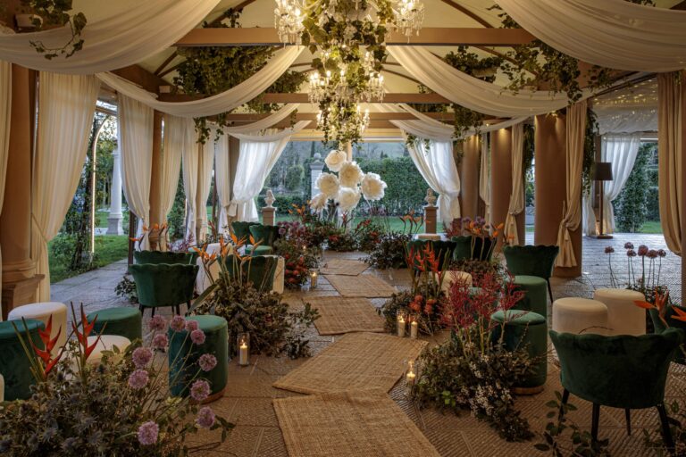A draped garden pavilion with a chandelier, green velvet seating and tropical flowers, Il Giorno Perfetto di Glenda Marradi