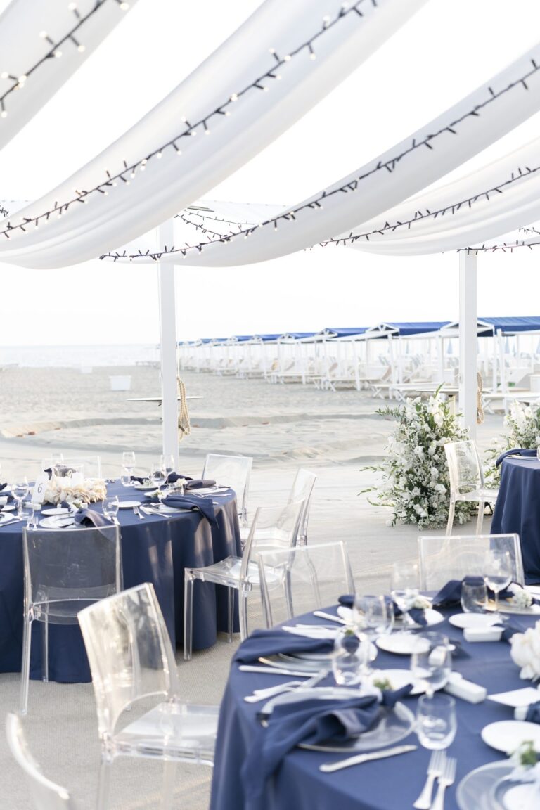 Navy linen and clear chairs under a white canopy strung with lights, the sea beyond, Il Giorno Perfetto di Glenda Marradi