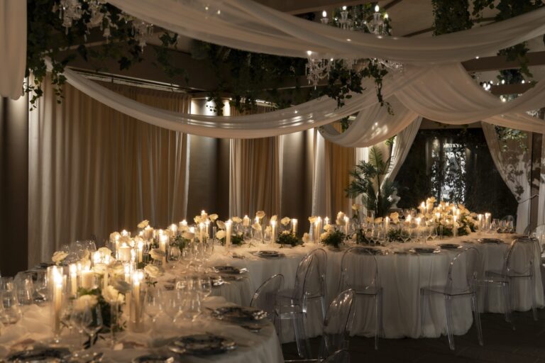 White draped reception room with long candlelit tables, white roses and clear chairs, Il Giorno Perfetto di Glenda Marradi