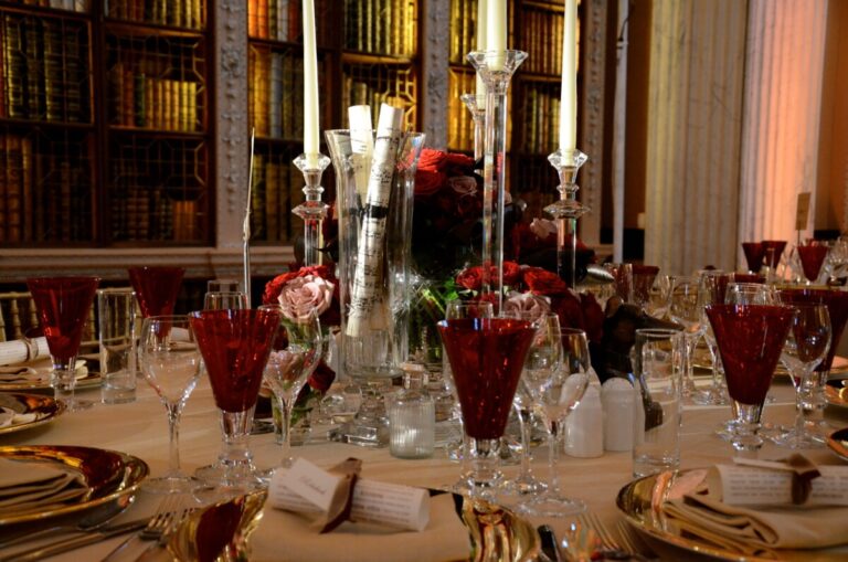 A candlelit library dinner, red glassware and deep-toned roses, In Water Flowers