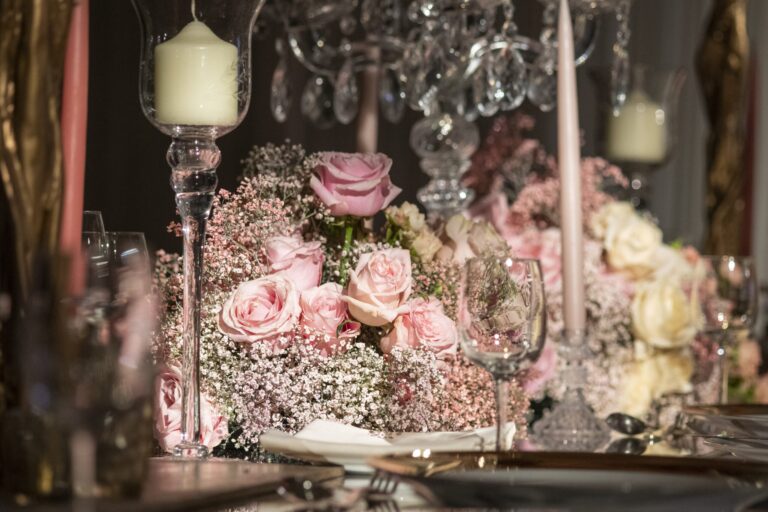 Pink roses, gypsophila, crystal candle holders and taper candles on a wedding table in the Ballroom, InterContinental London Park Lane