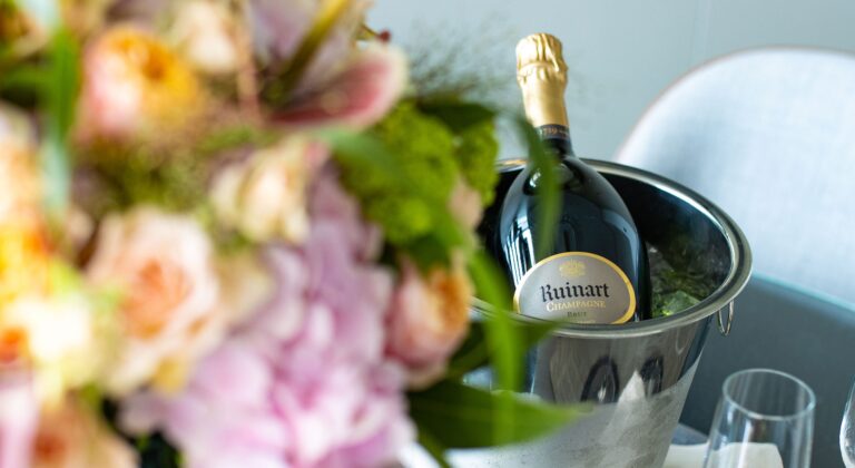A bottle of Ruinart in an ice bucket behind a posy of pink roses and hydrangeas, InterContinental London Park Lane