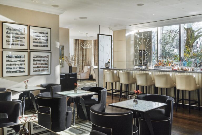 The Arch Bar, with velvet tub chairs, a pale bar counter and framed prints on the walls, InterContinental London Park Lane