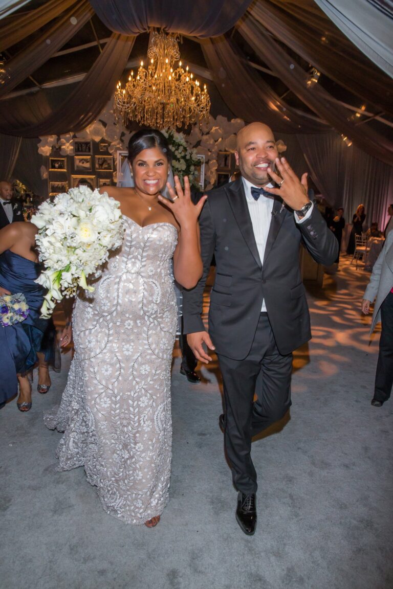 A bride and groom celebrating in a draped tent with a chandelier, International Event Company