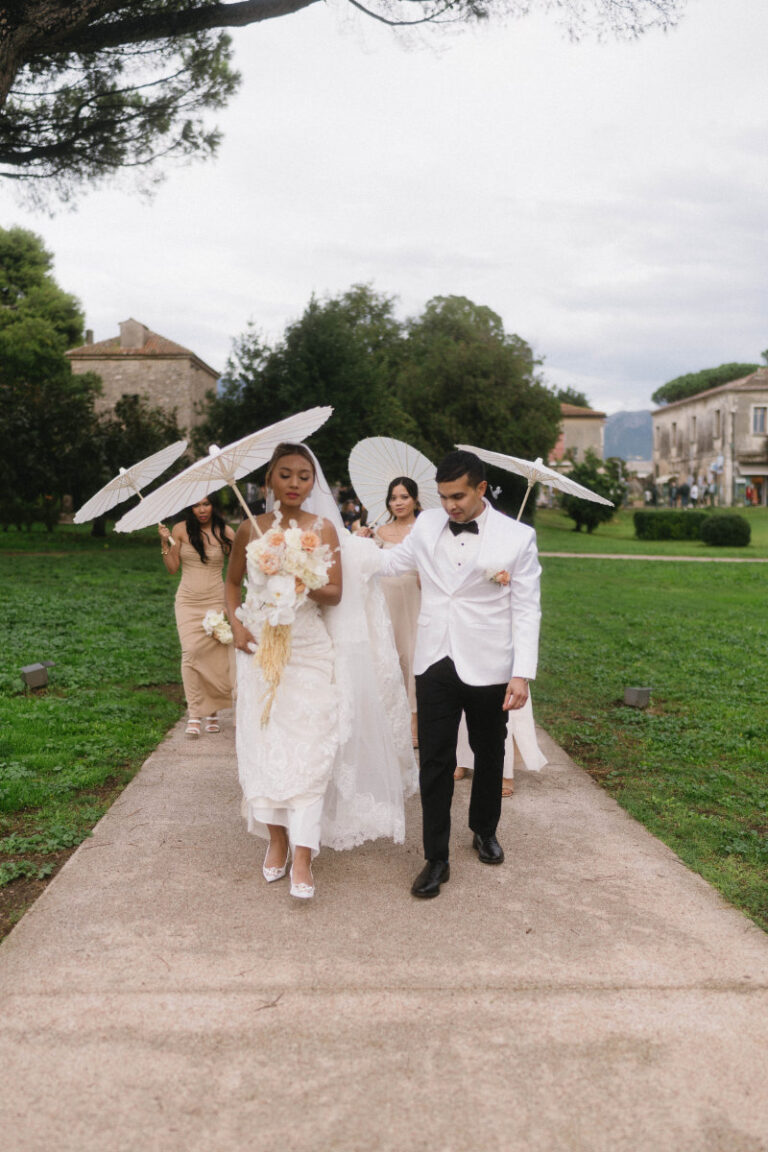 Walking the path with white parasols after the ceremony, Iole Criscitiello