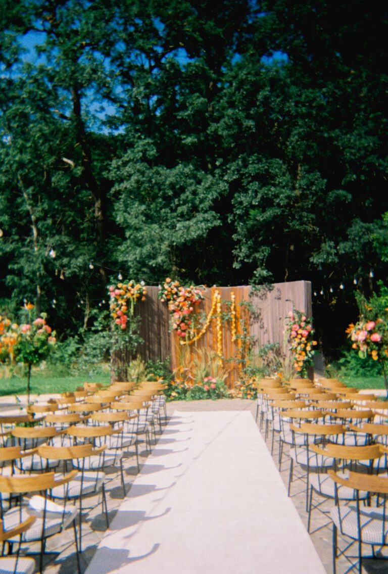 Ceremony aisle with a floral arch in the forest, Iris Orangerie