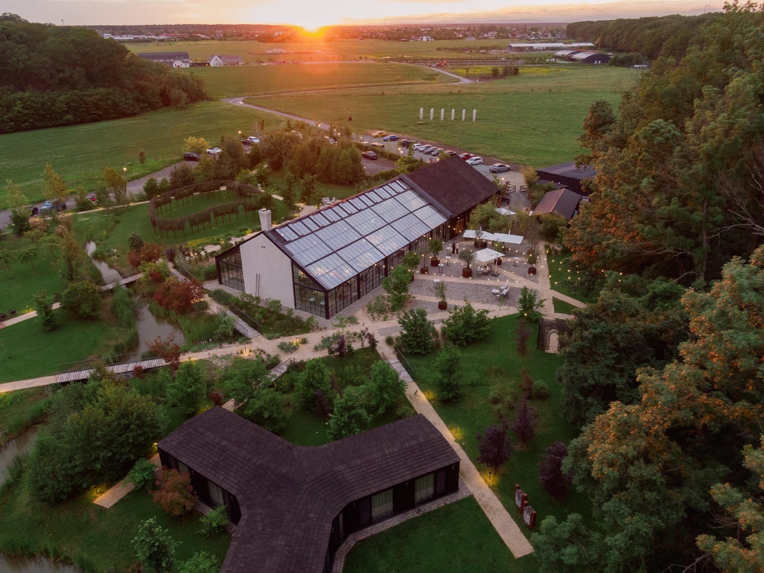 Aerial view of the glasshouse and estate at sunset, Iris Orangerie