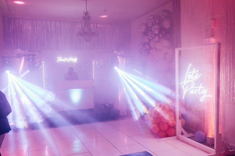 The dance floor under pink and violet lighting, a neon sign glowing at the far end, Iscoyd Park