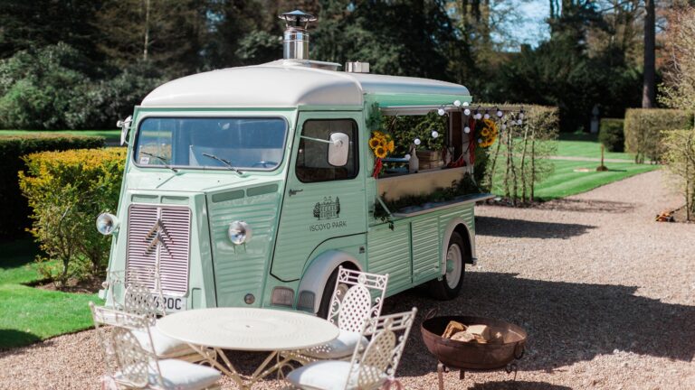 A vintage mint-green drinks van parked on the gravel drive beside a cafe table, Iscoyd Park