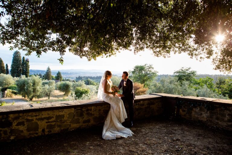A couple under an olive tree on a stone terrace above Florence at sunset, Italian Event Planners