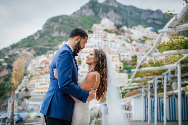 A couple kissing under a flowering tree on a Positano beach path at dusk, Italian Event Planners