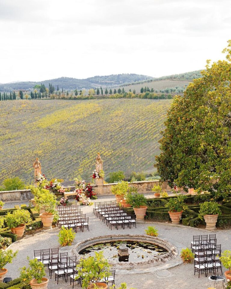 A vineyard terrace ceremony in Tuscany with chairs circling a stone lily pond, Italian Eye