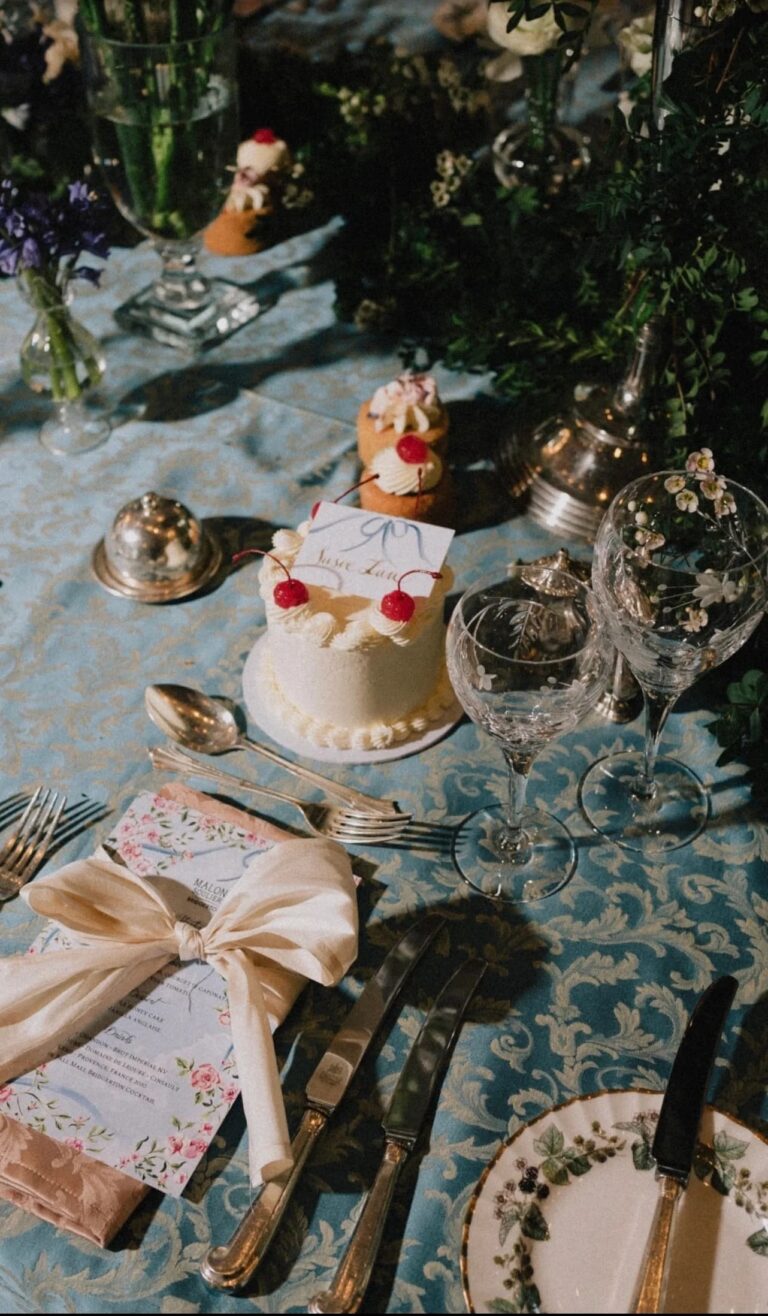 A dessert table on powder-blue damask with cherry-topped petit cakes and etched glassware, Italian Eye