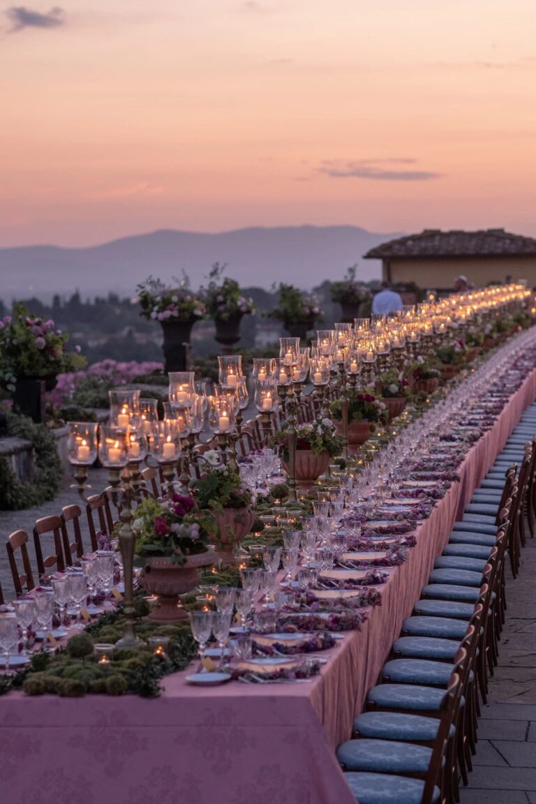 A rooftop table at sunset with brass candelabra and terracotta urns above the Tuscan hills, Italian Eye
