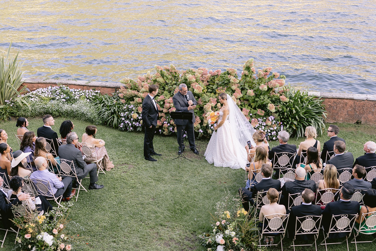 Lakeside garden ceremony with guests seated facing the water, Lake Como, Italian Wedding